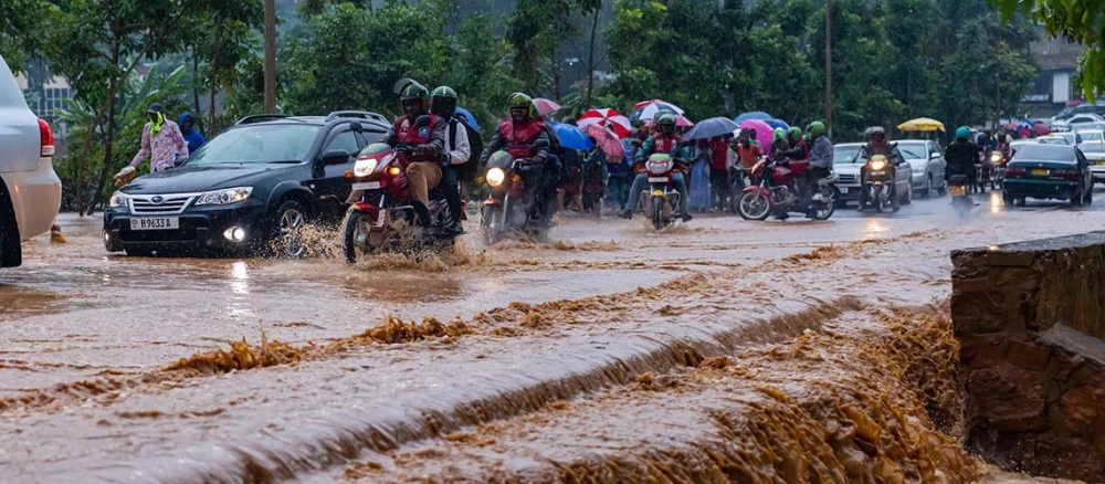 Taxi-moto operators and vehicles wade through a flooded street in Kigali on May 2, 2023. The weather forecast, released on May 2, states that the first 10 days of May 2023 are expected to be wetter than usual. File 