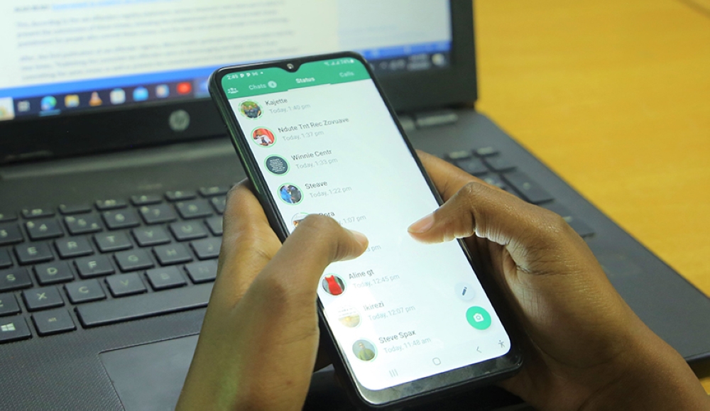 A person uses a mobile phone to carry out a transaction. A new report by TransUnion that was released on Tuesday shows that at least 32 percent of Rwandans were targeted by fraud and money mule scams from September to December 2022. Photo: File.