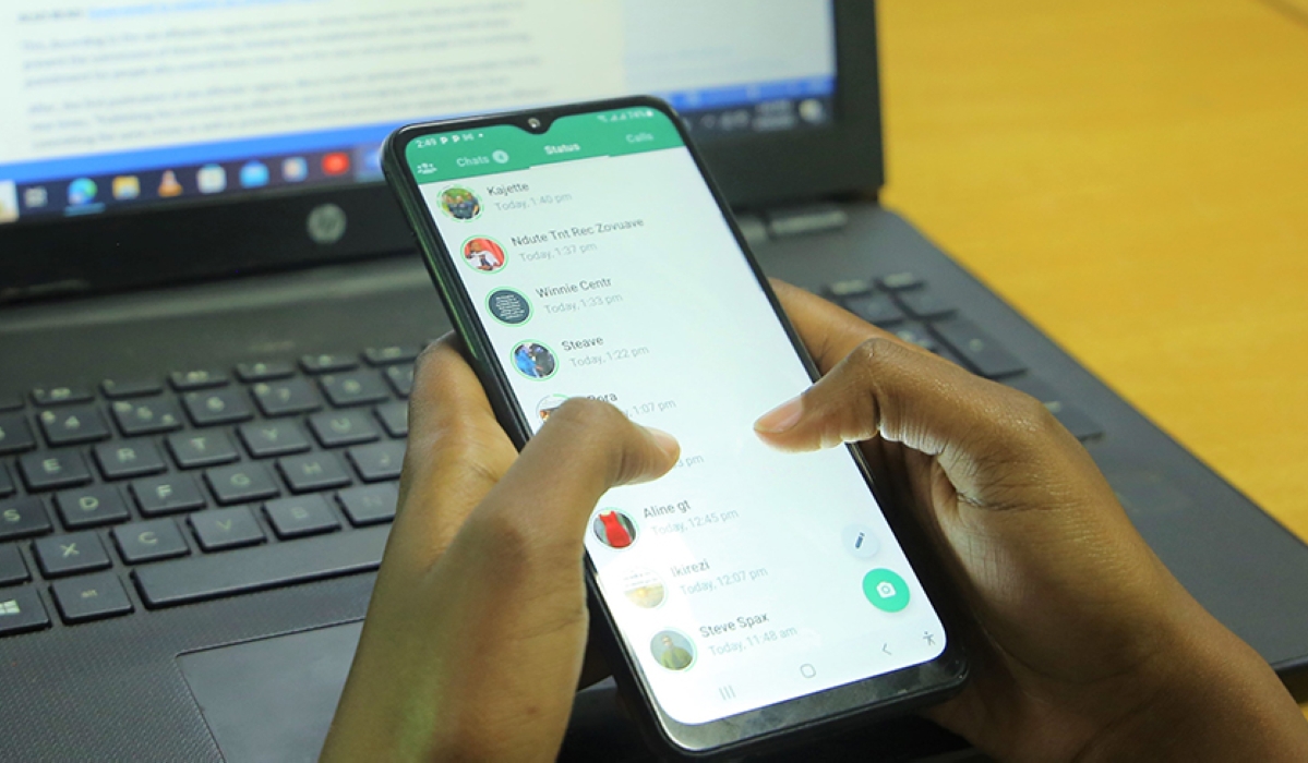 A person uses a mobile phone to carry out a transaction. A new report by TransUnion that was released on Tuesday shows that at least 32 percent of Rwandans were targeted by fraud and money mule scams from September to December 2022. Photo: File.