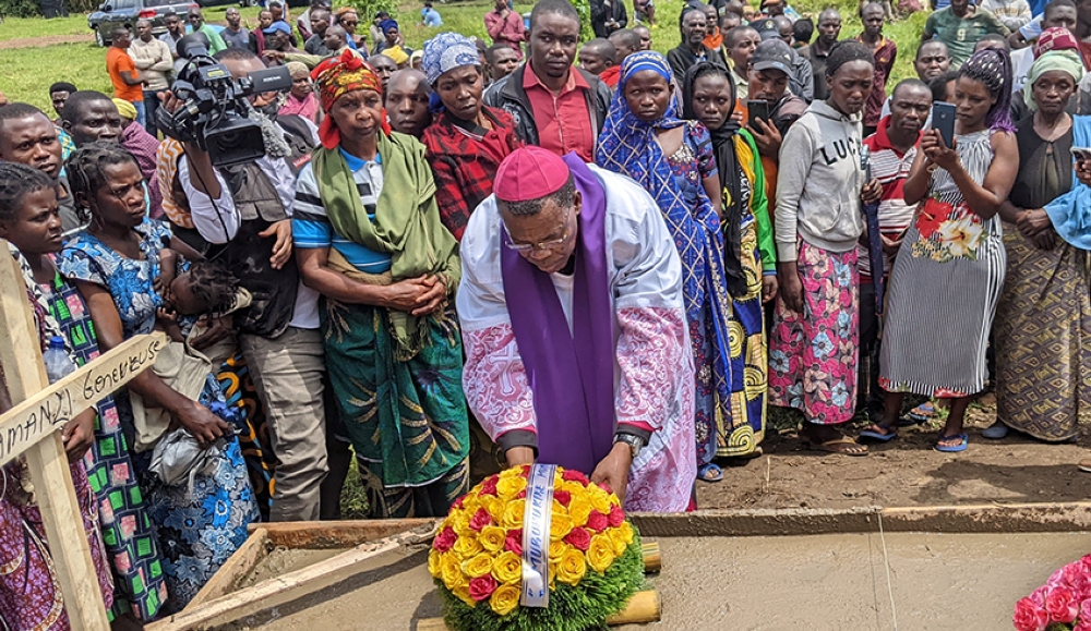 Anaclet Mwumvaneza of Nyundo Catholic Diocese lays a wreath on one of the graves of the victims of flood and landslide disasters in Rubavu District on Thursday, May 4. Photo by Germain Nsanzimana