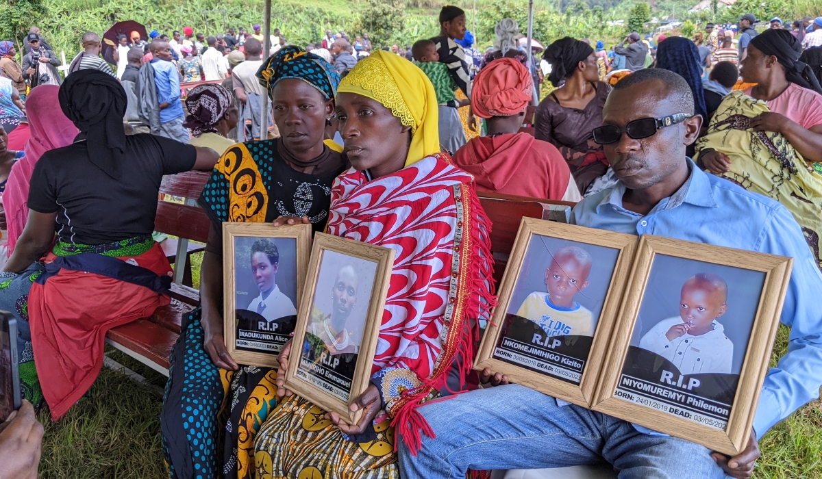 Lucia Ingabire (c) with his family carrying the portrait of her three children and husband who lost their lives in heavy rain-caused floods and landslides in  Northern and  Southern province  during the burial ceremony in Rubavu district on May 5 2023 Photo by Germain Nsazimana 