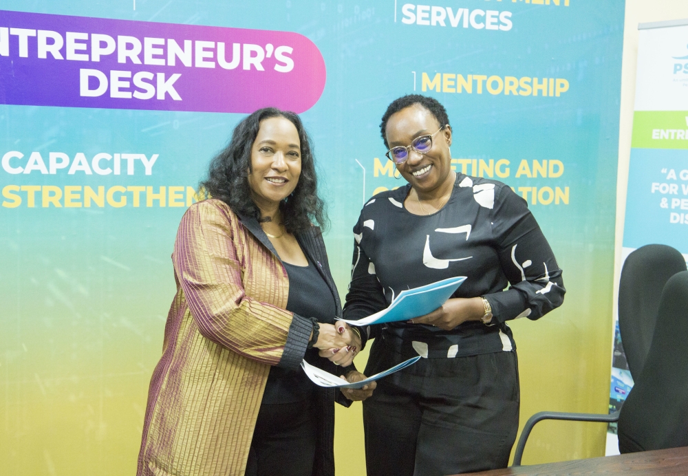 Pamela Coke-Hamilton, Executive Director of ITC and Therese Sekamana, Chairperson of PSF Specialized Cluster exchange documents during the signing ceremony in Kigali on May 9. Emmanuel Dushimirimana