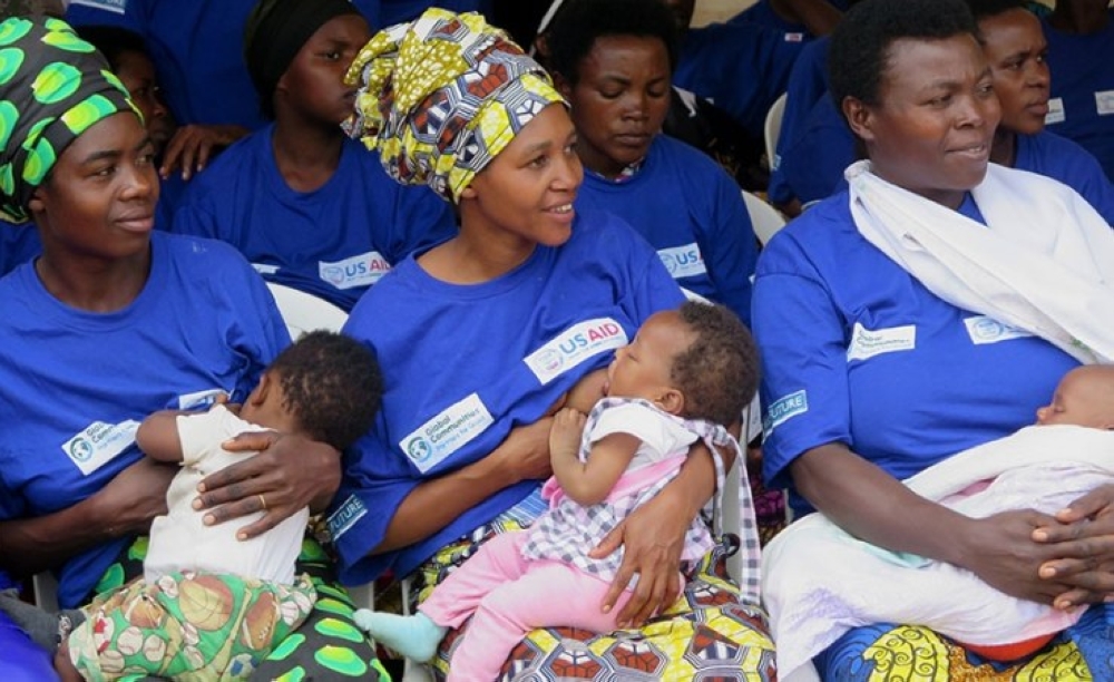 Mothers breastfeed their children during a campaign. File