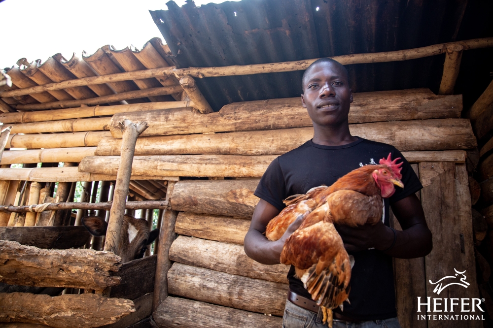 Felix Ngogoza holding a chicken.