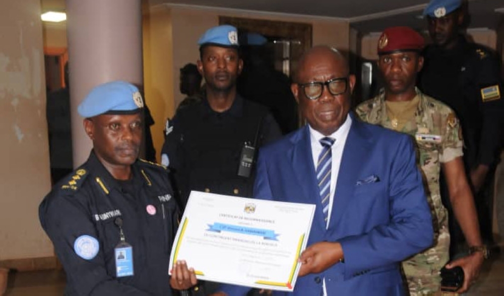 CAR Prime Minister, Felix Moloua, gives a certificate to the Rwanda Protection Support Unit contingent commander, CSP Vincent B. Habintwari.