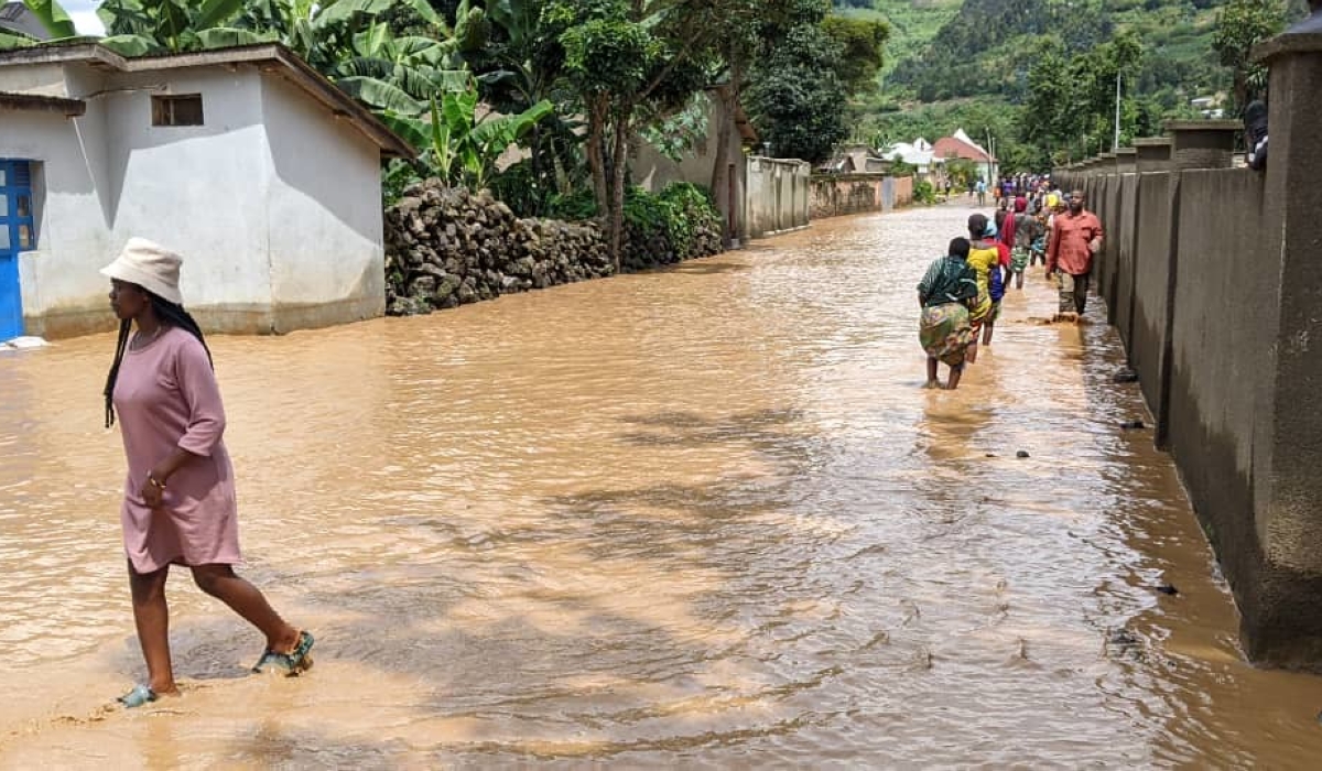 Residents wade through a flooded residential area on May 3. Rwanda secures $98 million, through the  initiative that aims at helping address longer-term structural challenges such as climate change. Germain Nsanzimana