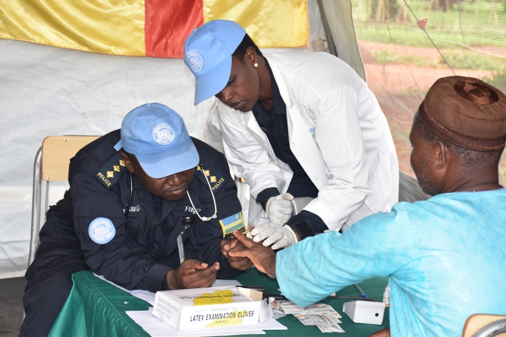Rwandan police peacekeepers take blood tests from one of the patients during the medical outreach.