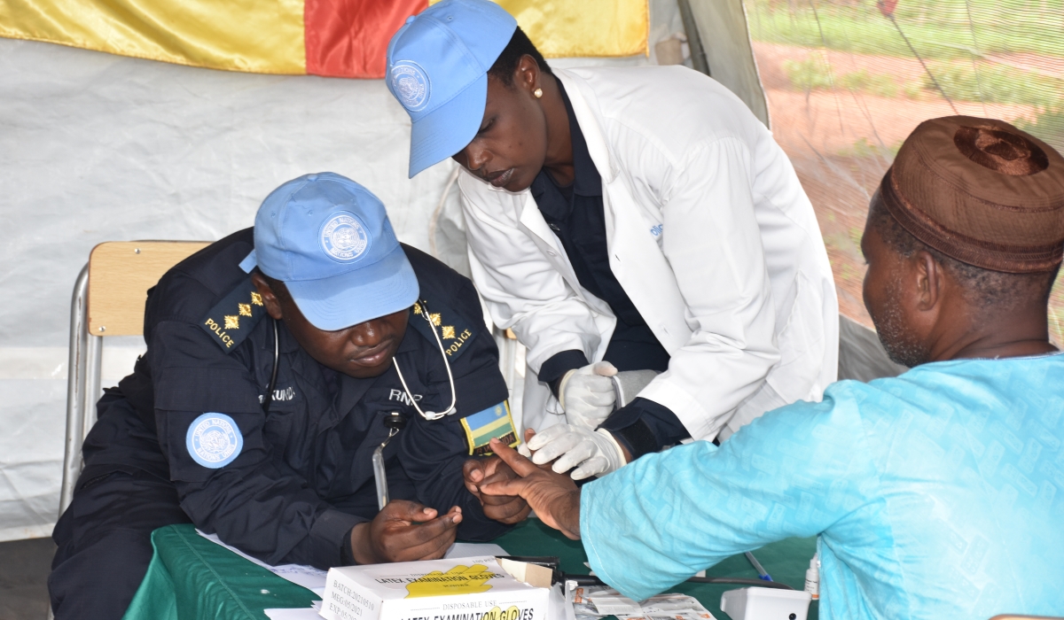 Rwandan police peacekeepers take blood tests from one of the patients during the medical outreach.