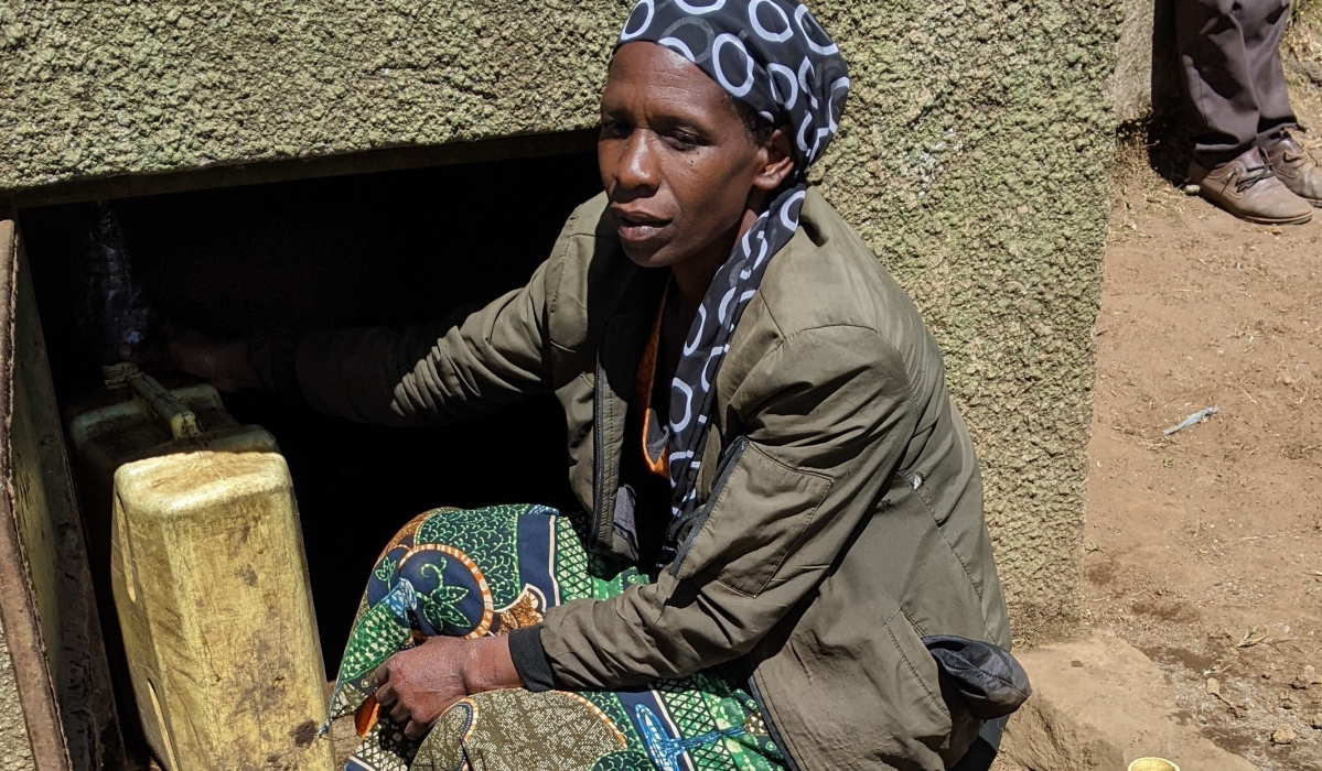 A woman fetches water from one of the rainwater harvesting tanks in Musanze District. Photo:
Germain Nsanzimana.