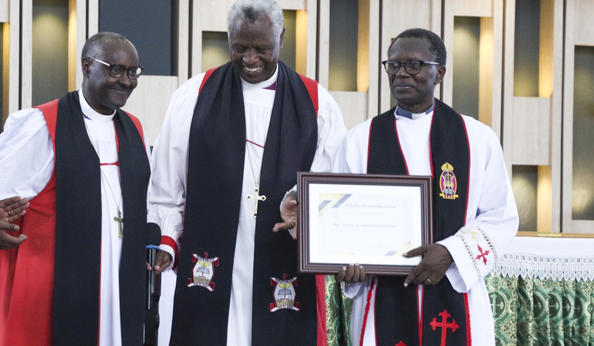 Archbishop of the Anglican Church of Rwanda Laurent Mbanda (C) and Bishop of Kigali Rev Nathan Rusengo Amooti (Left) hand over a certificate of appreciation to Rev Antoine Rutayisire during the inauguration of a new church of EAR Remera Parish in Gasabo on Sunday, June 4. Photo by Emmanuel Dushimimana