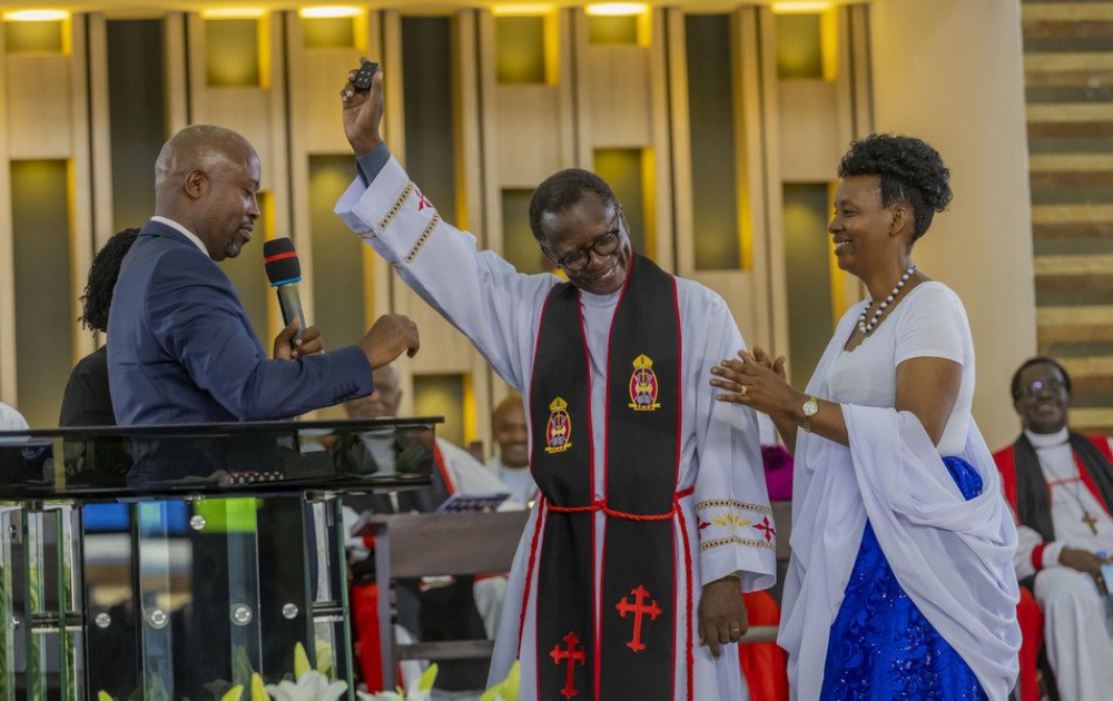 Sam Nkurunziza, the head of EAR Remera congregation (left), handing over car keys to the retiring Reverend Canon Antoine Rutayisire (center), as the latter’s wife, Penina Kayitesi, claps, on Sunday, June 4. Upon his retirement, Christians gifted Rutayisire with a brand new Toyota Fortuner 2023 as a sign of gratitude. Courtesy