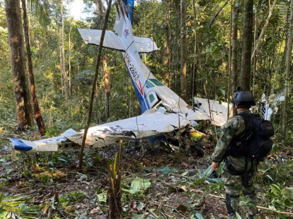 A photo released by Colombia’s Armed Forces Press Office, showing a soldier standing in front of the wreckage of the Cessna 206 on May 18, over two weeks after it crashed in the jungle of Solano in the Caqueta state of Colombia [Colombia’s Armed Forces Press Office via AP]