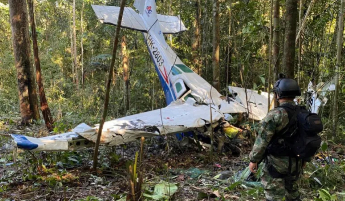 A photo released by Colombia’s Armed Forces Press Office, showing a soldier standing in front of the wreckage of the Cessna 206 on May 18, over two weeks after it crashed in the jungle of Solano in the Caqueta state of Colombia [Colombia’s Armed Forces Press Office via AP]