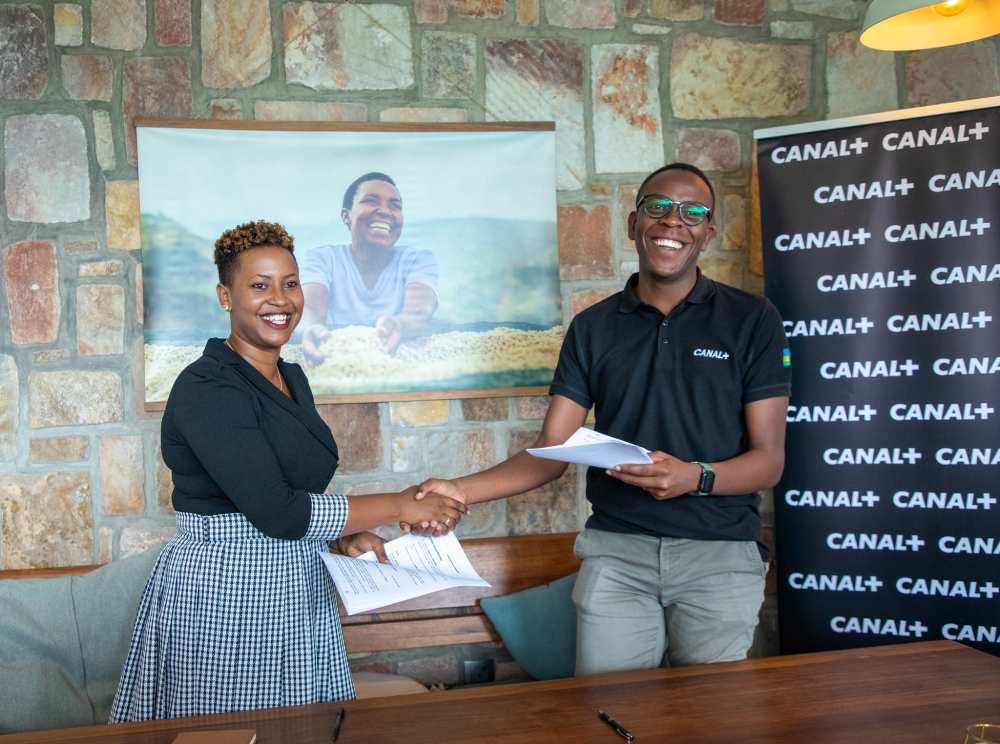 Aimé Abizera, the Sales Director at Canal Plus and Jackie Mutesi, the Executive Director of Kula Project, shake hands after signing the agreement on Friday, June 16. Dan Kwizera