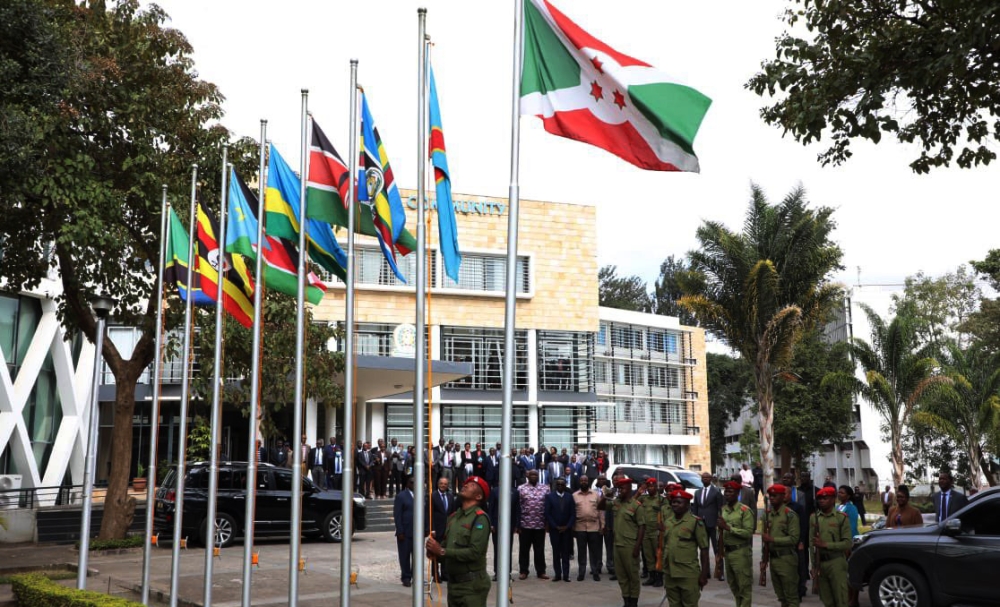 Officers hoist EAC flags during an event at the East African Community headquarters in Arusha on July 11,2021.EALA urged the region to expedite sanctions against Partner States who do not honour their contribution.