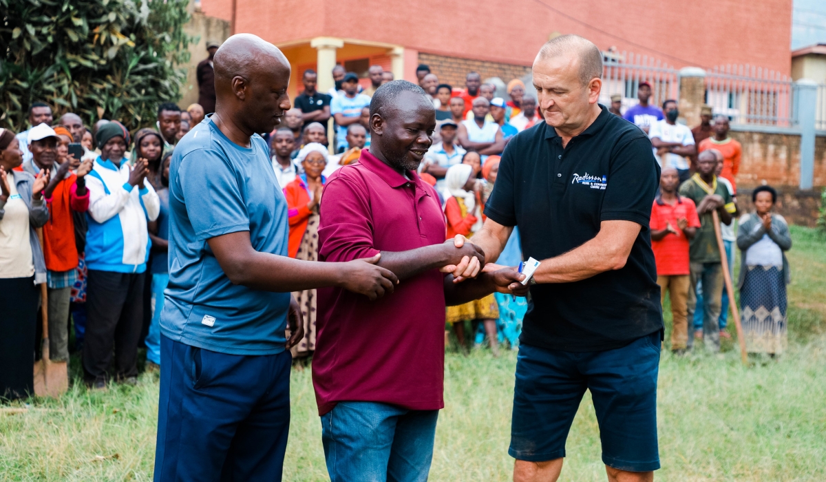 Rob Kucera, the District Director of East Africa, Complex General Manager - Radisson Blu Hotel and Convention Centre hands over the Community-Based Health Insurance, known as &#039;Mutuelle de Sante&#039; for 300 families in Jali.