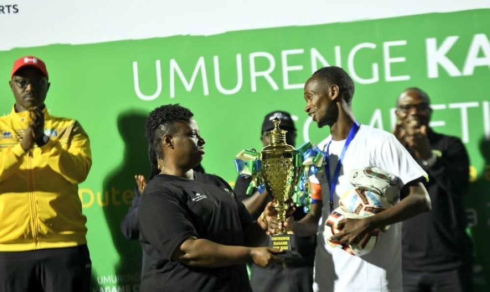 RGB CEO Dr Usta Kaitesi(C) hands over the trophy to Nyarugenge Sector football team who were crowned Umurenge Kagame Cup 2023 champions as City Mayor Pudence Rubingisa (L) watches on-courtesy