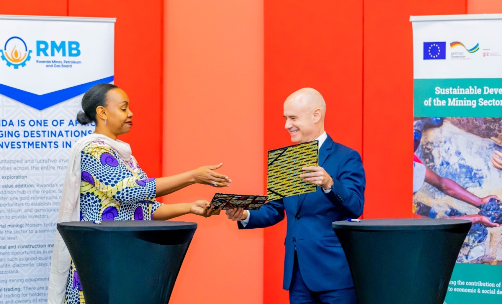 Yamina Karitanyi, Chief Executive Officer of the Rwanda Mines, Petroleum, and Gas Board and Martin Kraft, GIZ Country Director exchange documents during the signing of the agreement in Kigali on Monday, June 26. Courtesy