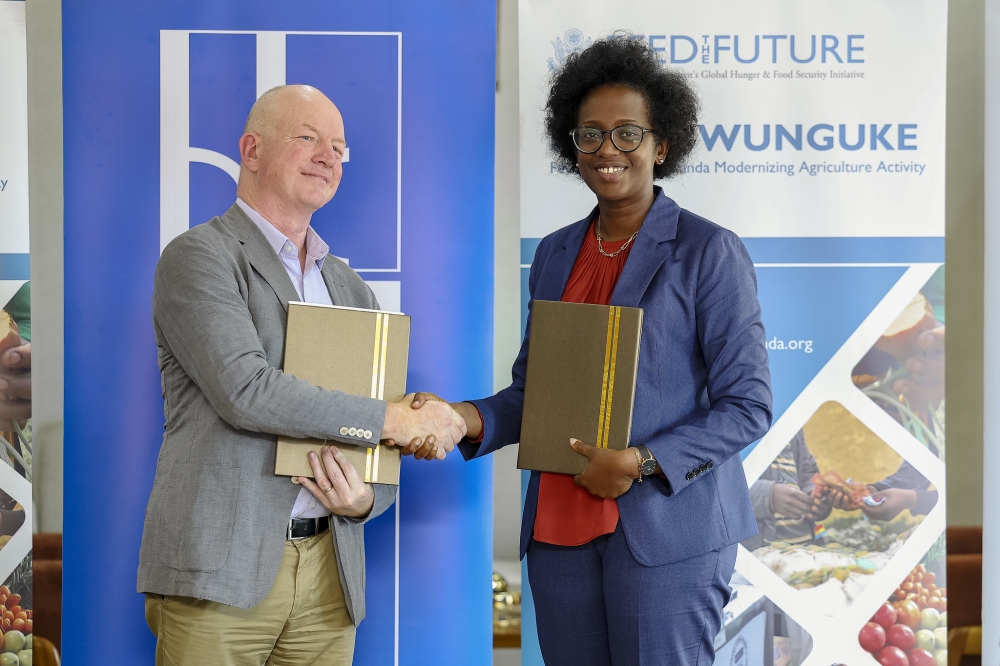Diane Karusisi, CEO of Bank of Kigali and Daniel Gies , Chief of Party, Feed the Future - Hinga Wunguke Activity exchange documents during the signing ceremony in Kigali on June 30. Photos by Christianne Murengerantwari