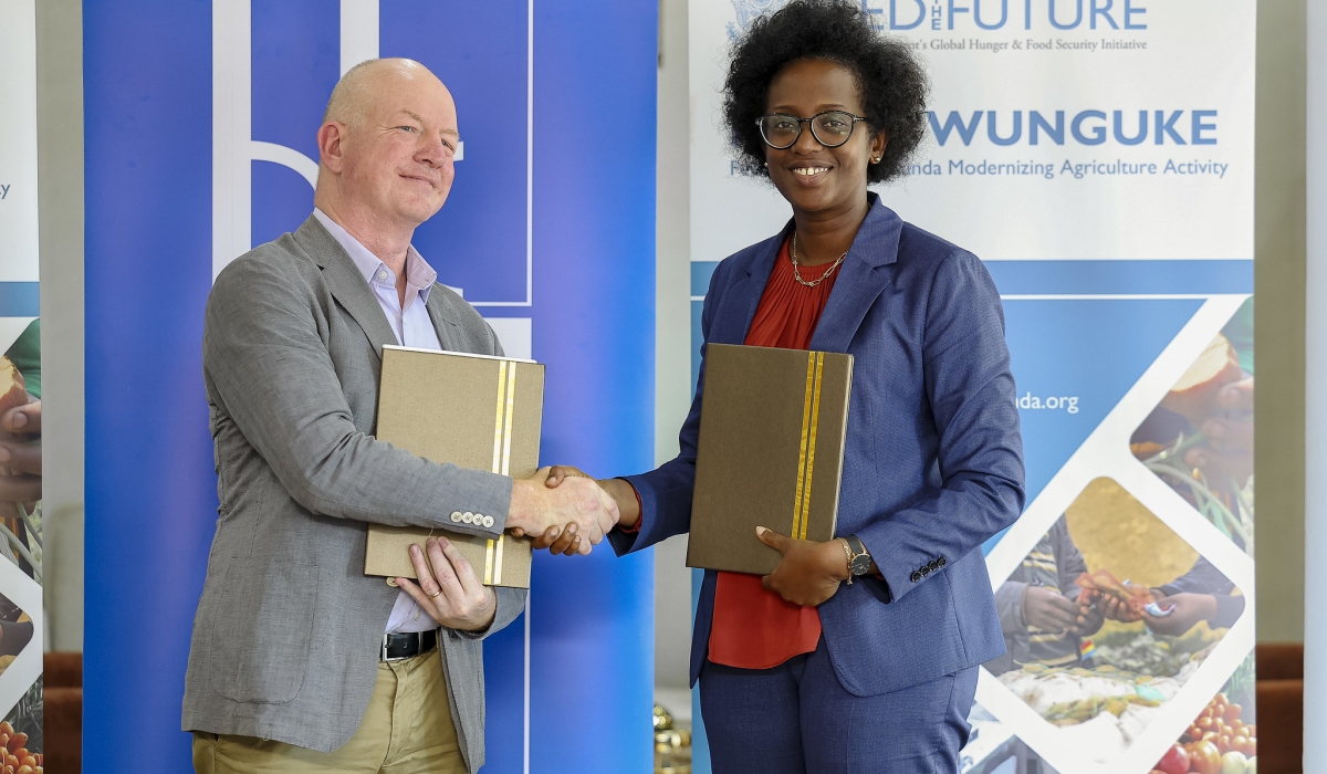 Diane Karusisi, CEO of Bank of Kigali and Daniel Gies , Chief of Party, Feed the Future - Hinga Wunguke Activity exchange documents during the signing ceremony in Kigali on June 30. Photos by Christianne Murengerantwari