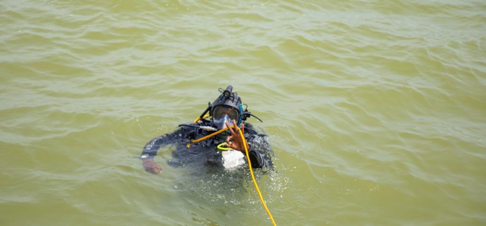 A marine police officer makes a countdown before taking a dive