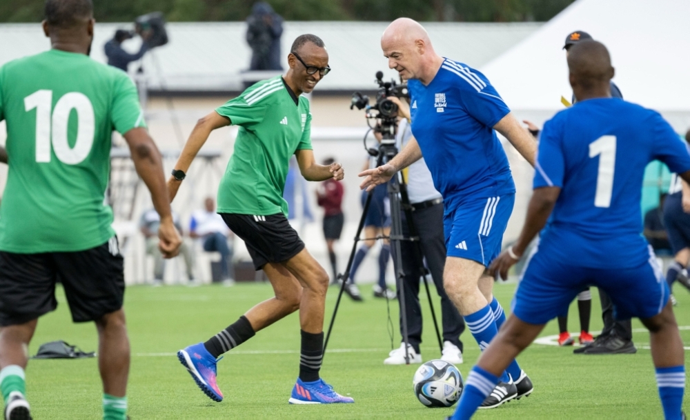 FIFA president Gianni Infantino controls the ball as he tries to go past President Paul Kagame during the match at the inauguration of Kigali Pele Stadium on March 15. Photo by Village Urugwiro