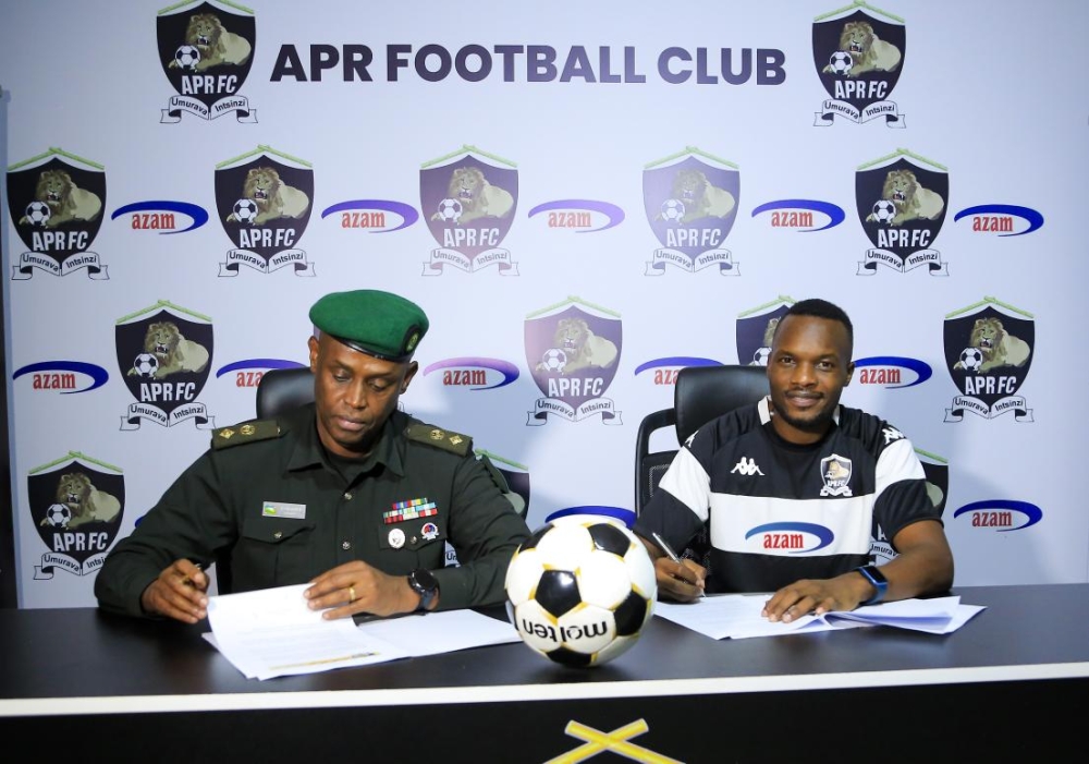 Ugandan midfielder Taddeo Lwanga (R) with APR chairman Lt Col Richard Karasira signing the deal
