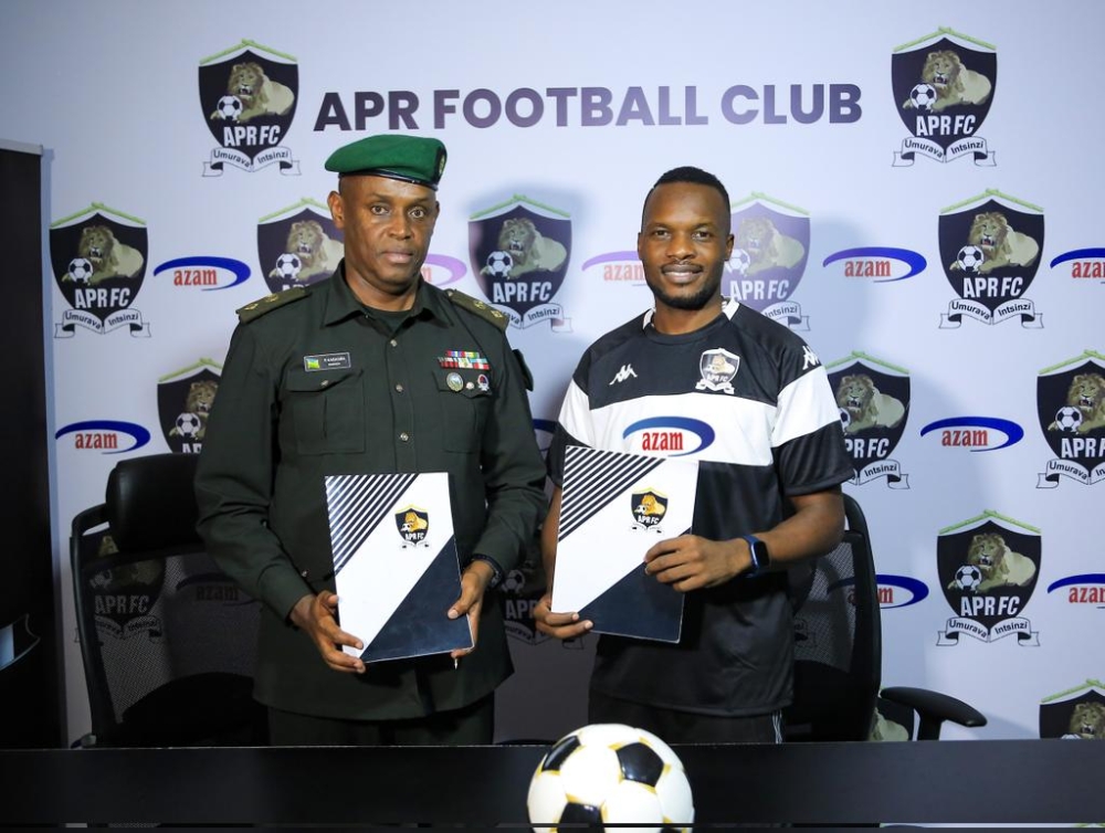 Ugandan midfielder Taddeo Lwanga (R) with APR chairman Lt Col Charles Karasira after putting pen to paper as club new signing-courtesy