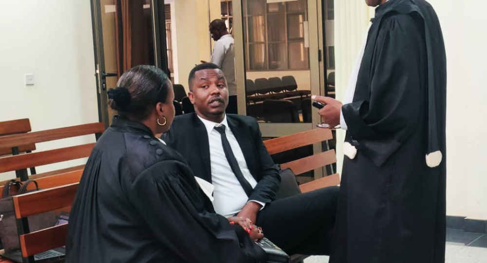 Dieudonne Ishimwe, also known as Prince Kid chats with his lawyers.The High Court in Nyamirambo has postponed the hearing in the case of Dieudonne Ishimwe, to September 15.