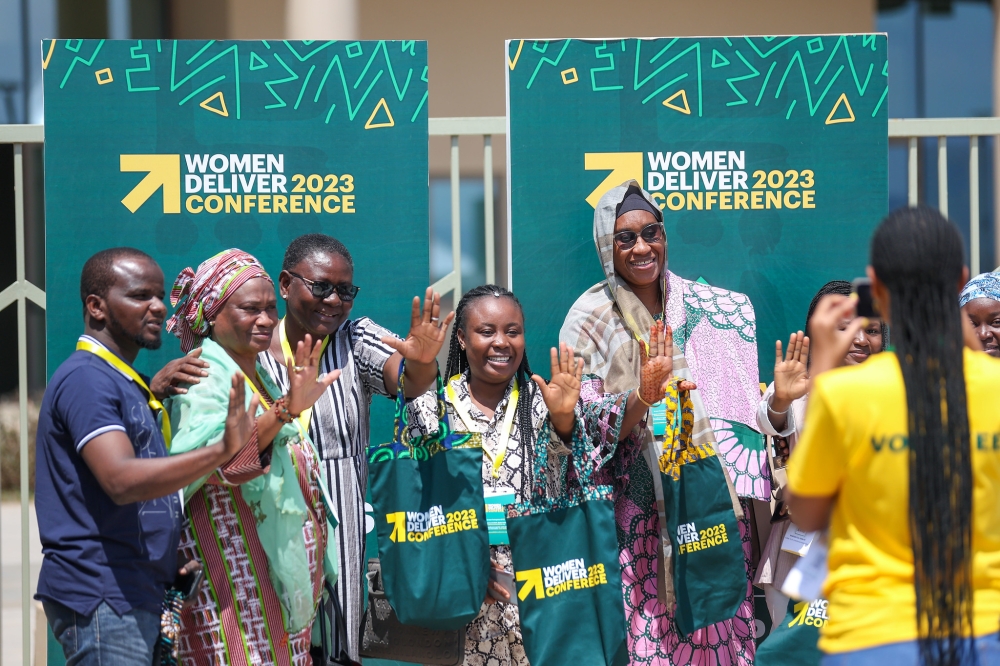 Delegates cheer on a photographer as they pose for a photo after picking their badges.