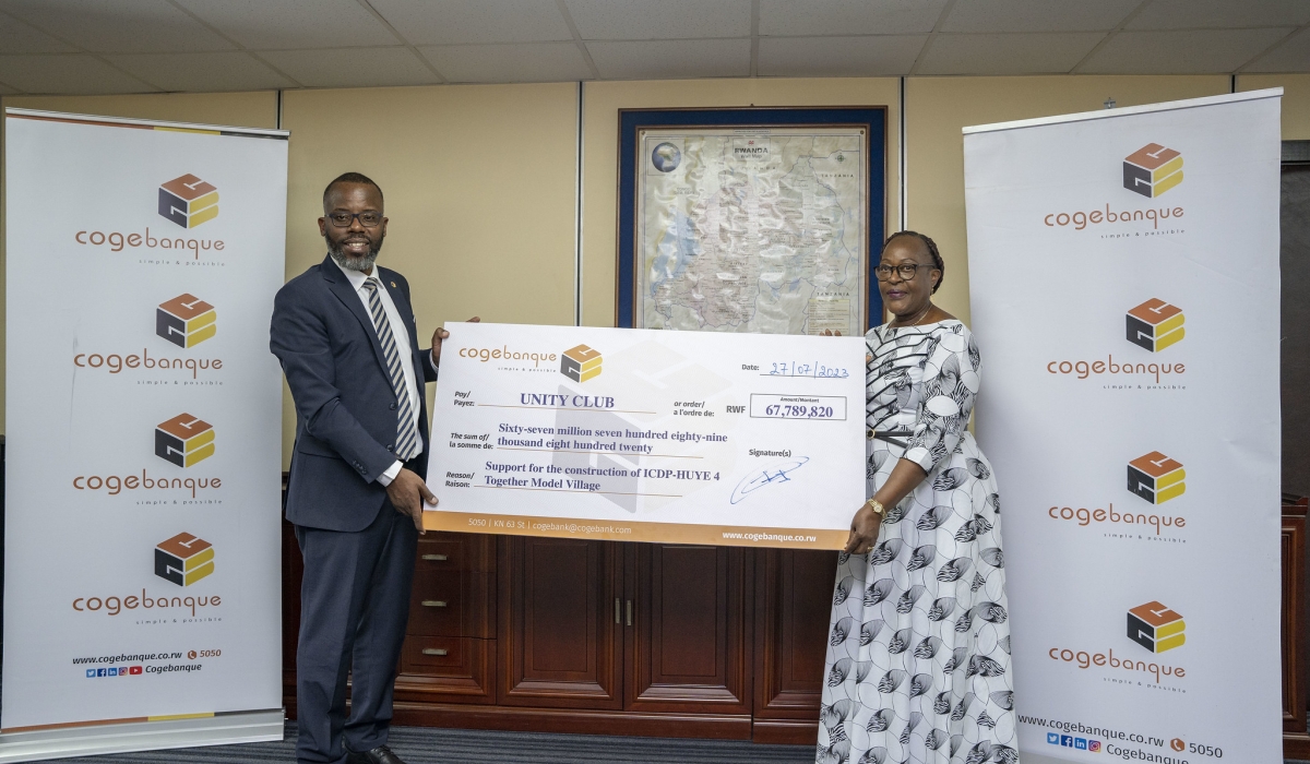 Guillaume Ngamije Habarugira, the CEO of Cogebanque hands over a cheque to Régine Iyamuremye, the Executive Secretary of Unity Club Intwararumuri  at the event on Thursday, July 27. Photos by Emmanuel Dushimimana