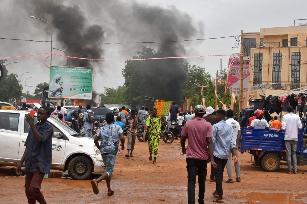 A general view of billowing smoke as supporters of the Nigerien defence and security forces attack the headquarters of the Nigerien Party for Democracy and Socialism (PNDS), the party of overthrown President Mohamed Bazoum, in Niamey on July 27, 2023. (Photo by AFP) (Photo by -/AFP via Getty Images)