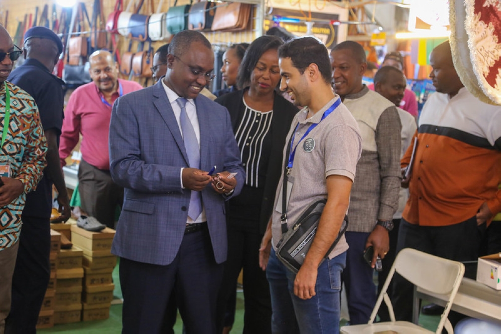 Minister of Trade Jean Chrysostome Ngabitsinze interacts with an exhibitor at Kigali International Trade Fair on July 30. PHOTOS BY CRAISH BAHIZI