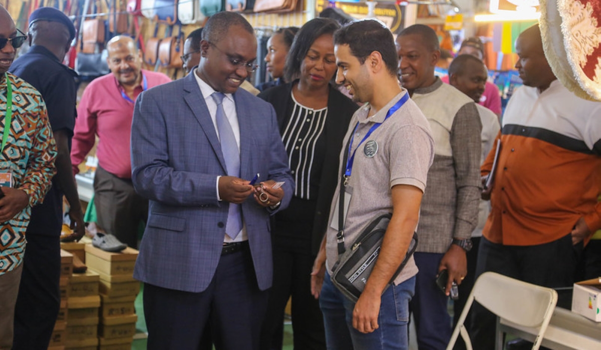 Minister of Trade Jean Chrysostome Ngabitsinze interacts with an exhibitor at Kigali International Trade Fair on July 30. PHOTOS BY CRAISH BAHIZI