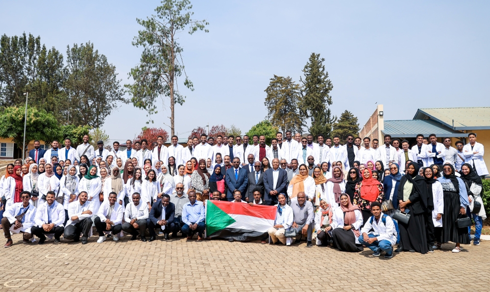 Officials pose for a group photo with  the 160 students from Sudan, at a reception event to welcome them to Rwanda