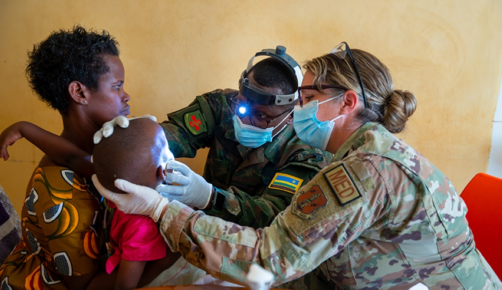 A member of RDF medical personnel and that of US armed force personnel examine a medical condition affecting a child in Bugesera District (courtesy)