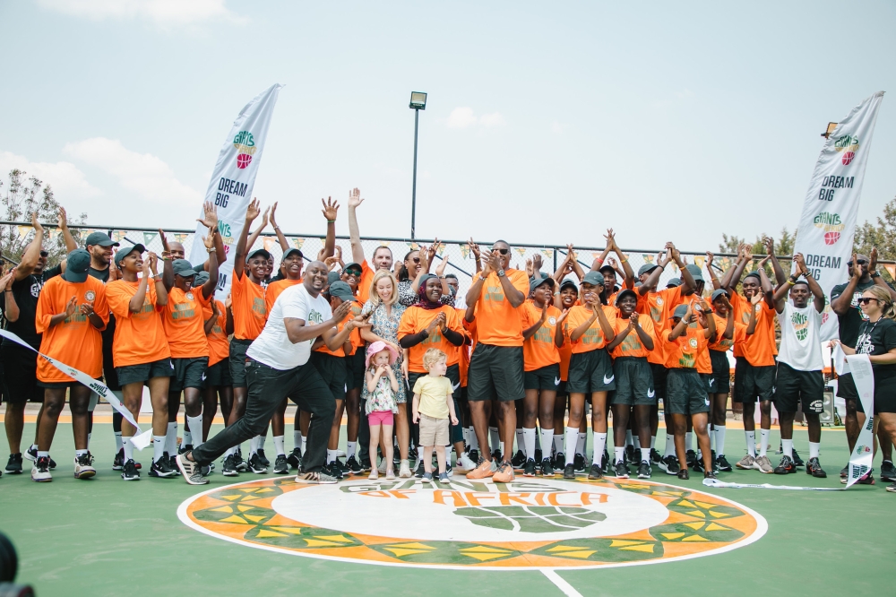 Delegates and students pose for a photo during the official launch of two new outdoor basketball courts  Sunday, August 13 in Rwamagana District, Eastern Province. ALL PHOTOS BY WILLY MUCYO