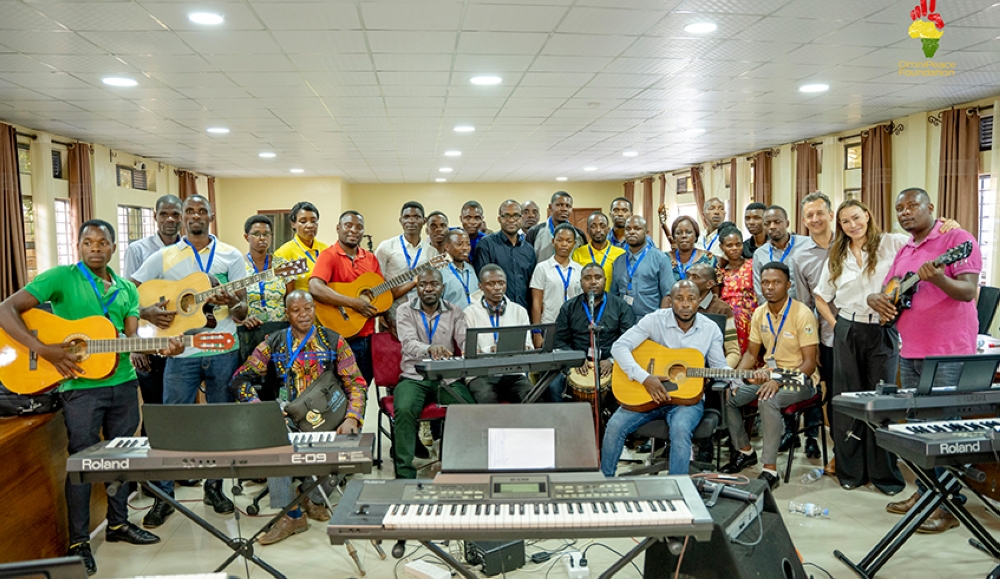 The music teachers who are being trained pose for a photo with Dr Richard Carrick, Chair of Music Composition at Berklee College of Music and Mary Fanaro, CEO Founder OmniPeace Foundation.