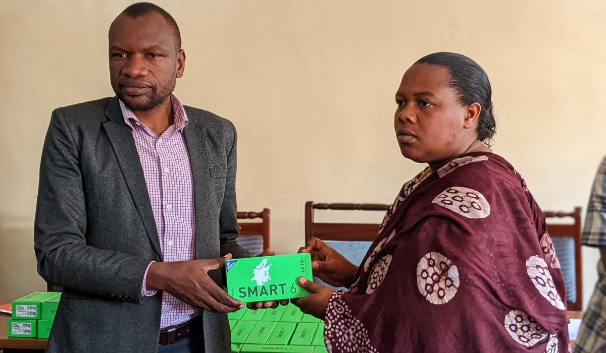 Vice Mayor for Economic Development and Acting Mayor of Burera District, Jean Baptiste Nshimyimana, hands over a new smartphone to one of the farmers. Photos by Germain Nsanzimana