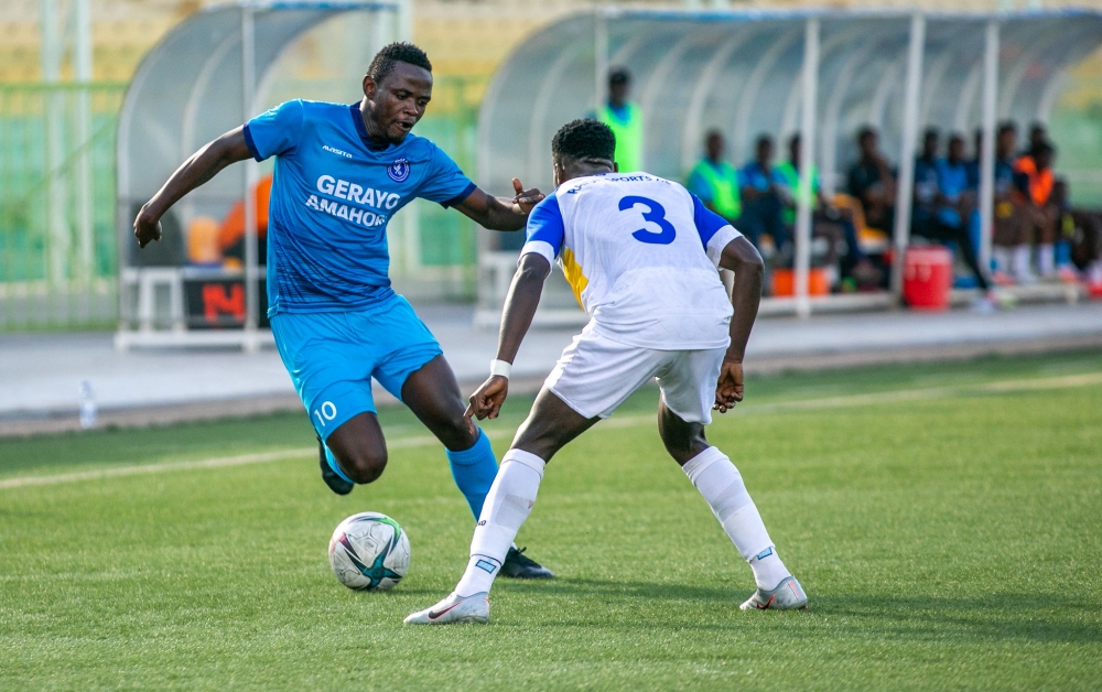 Forward Muhadjiri Hakizimana tries to go past Rayon Sports&#039; player during a league game. . Olivier Mugwiza