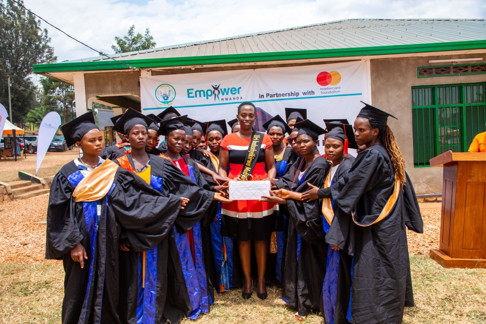 Some of the graduates present a gift to Olivia Promise Kabatesi, founder and country director of Empower Rwanda, in recognition of her efforts at the ceremony