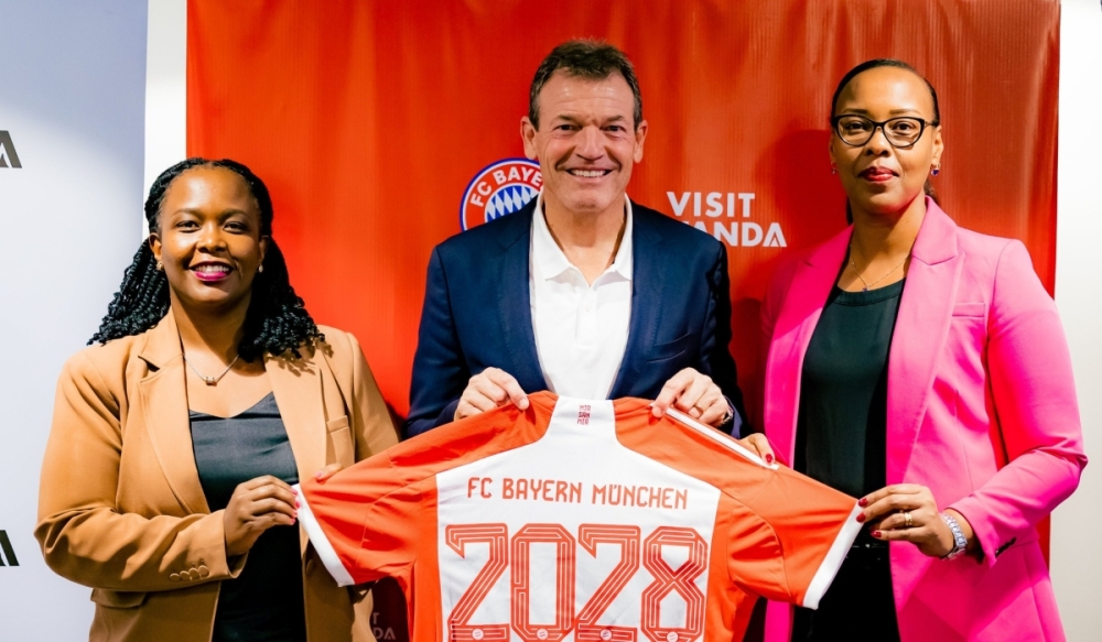 L-R: Clare Akamanzi, CEO of the Rwanda Development Board (RDB), Jan-Christian Dreesen, Bayern Munich Chief Executive Officer and Aurore Mimosa Munyangaju, the Minister of Sports hold a jersey of Bayern Munich after announcing the signing of a five-year partnership with the German football club on Sunday, August 27. COURTESY PHOTO