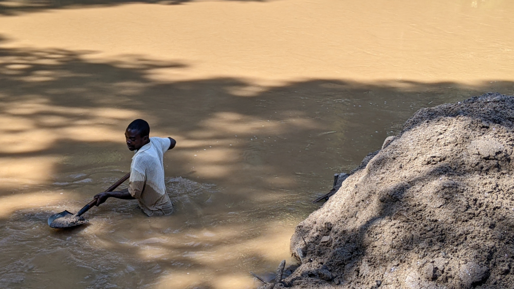 A local resident harvesting sand in Sebeya River.