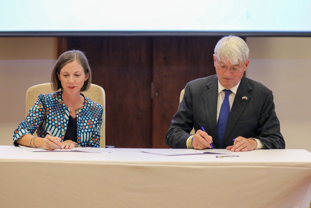 Julianna Lindsey, UNICEF Rwanda&#039;s Country Representative and Andrew Mitchell, the United Kingdom’s Minister of State for Development sign the agreement on August 31. Photos by  Dan Gatsinzi