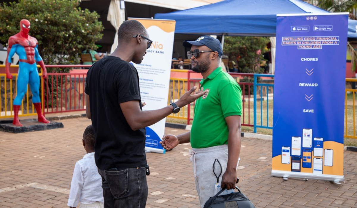 Jean Hubert Nkurayija Ishimwe, the founder and CEO of HiNia explaining to a parent how the application works during a children’s expo at Spiderman Game Centre, Masaka.