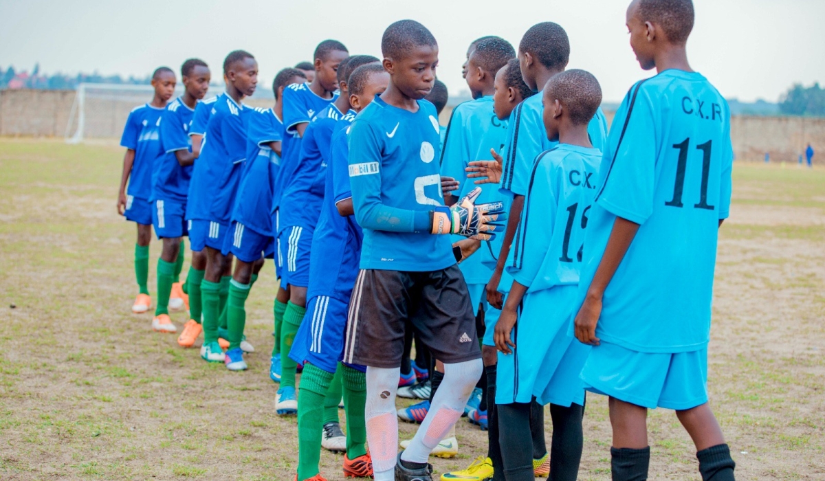 Teams of young football talents benefiting from Isonga Project greet each before a match between them during the closig ceremony of a weeklong camp held at College Christ Roi Nyanza from September 1-8-courtesy