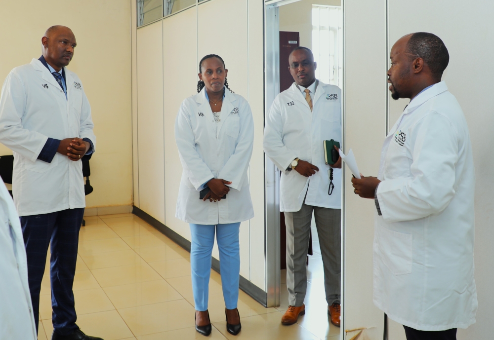 Deputy Director General at REMA Faustin Munyazikwiye (L), State Minister at the ministry of environment (c) Claudine Uwera during a guided tour of the newly launched centre of calibration laboratories. Courtesy