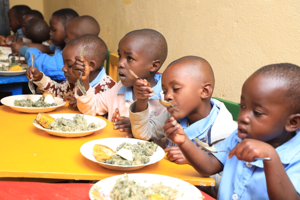 Children eat nutritious food at early childhood development centre in Nyamasheke District. Photo by Craish Bahizi