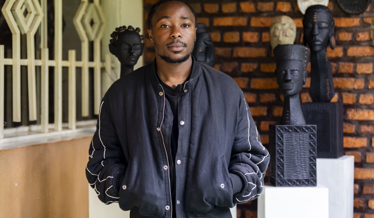 Rwandan Artist Claude Nizeyimana, poses near his artworks during the interview. Born and raised in Gisenyi, Rubavu district, He  knew deep down he loved art as a child. Photo by Christianne Murengerantwari
