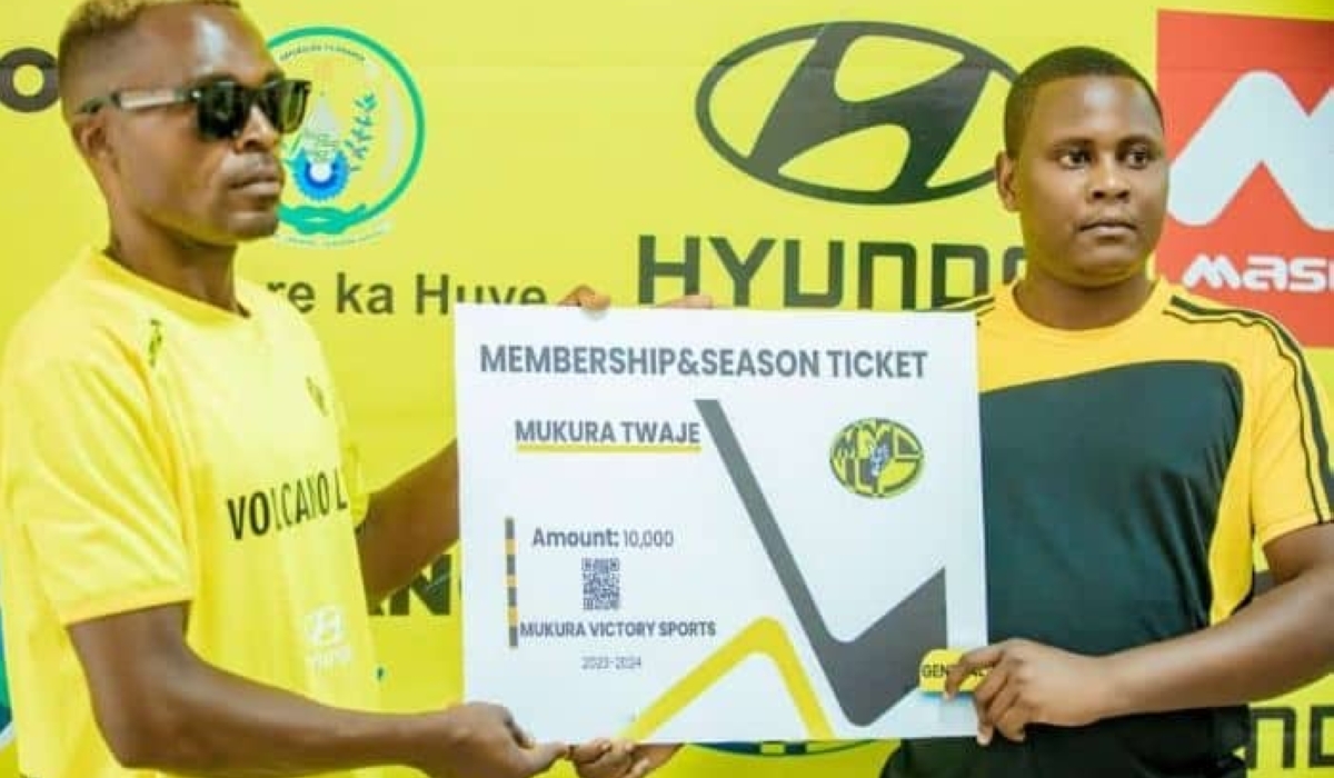 Board member of Mukura Victory Sports Protais Musoni (on the right) hands over the 10,000 RWF package to a fan.